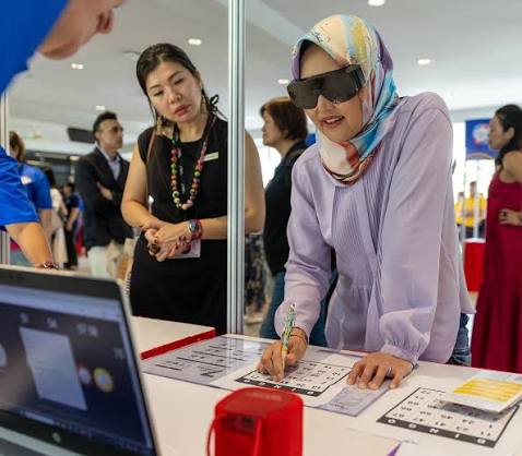 Guest of Honour Ms Rahayu Mahzam experiencing a visual impairment simulation activity