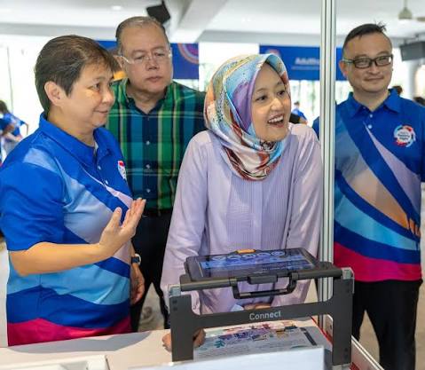 Guest of Honour Ms Rahayu Mahzam viewing an assistive technology demonstration
